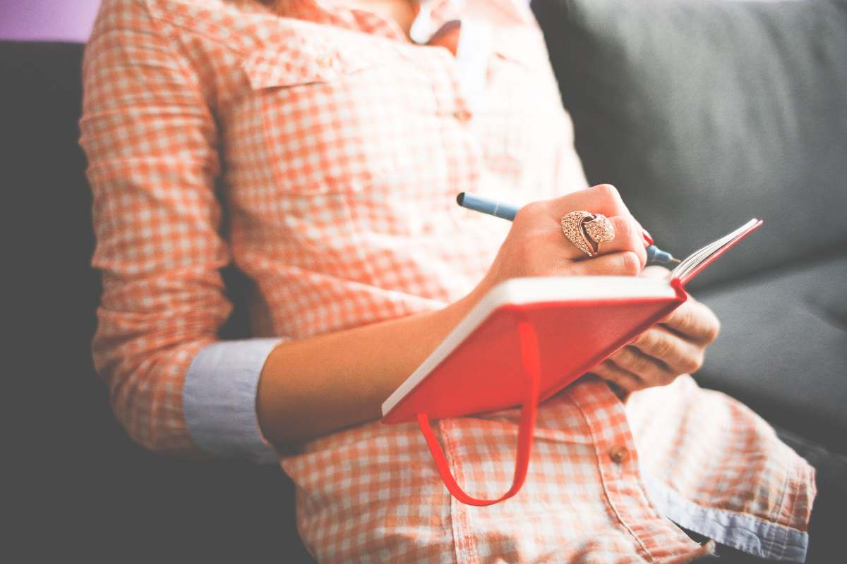 Woman writing reflections in a guided Bible journal during quiet time