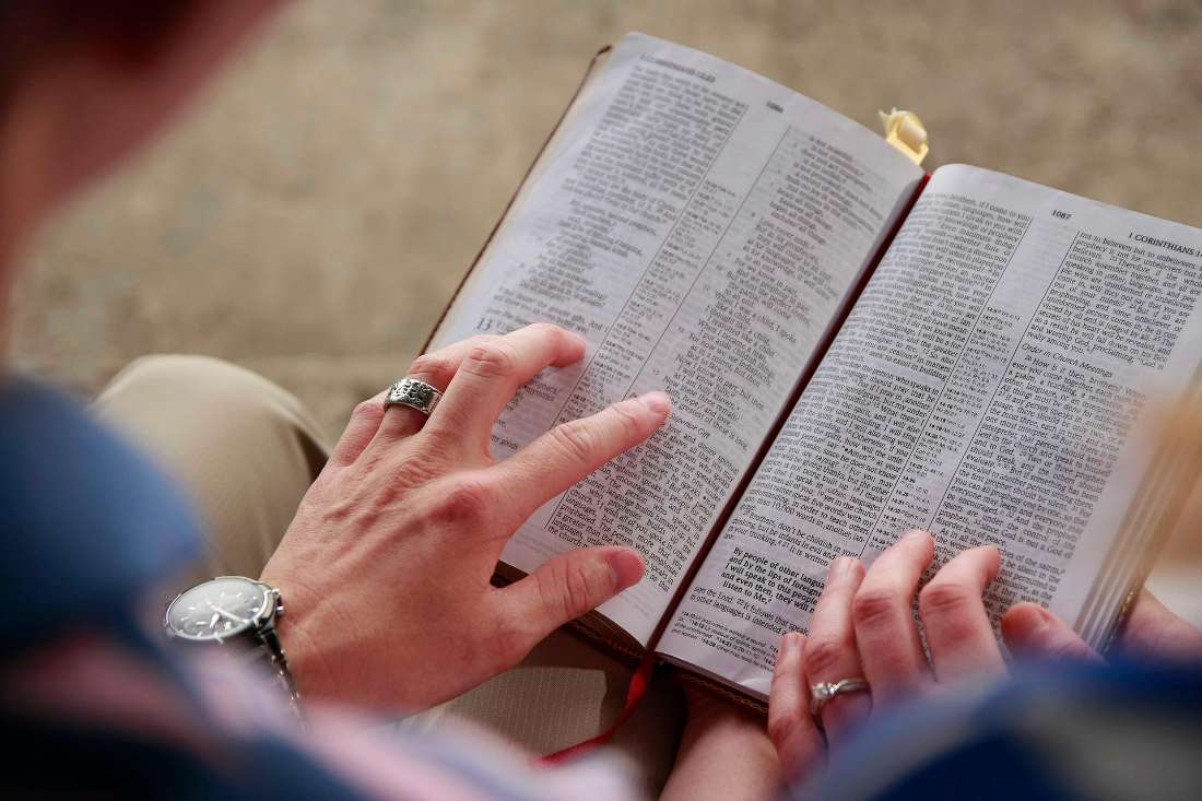 Hands resting on an open Bible passage during Scripture study, a habit a guided Bible journal for beginners builds