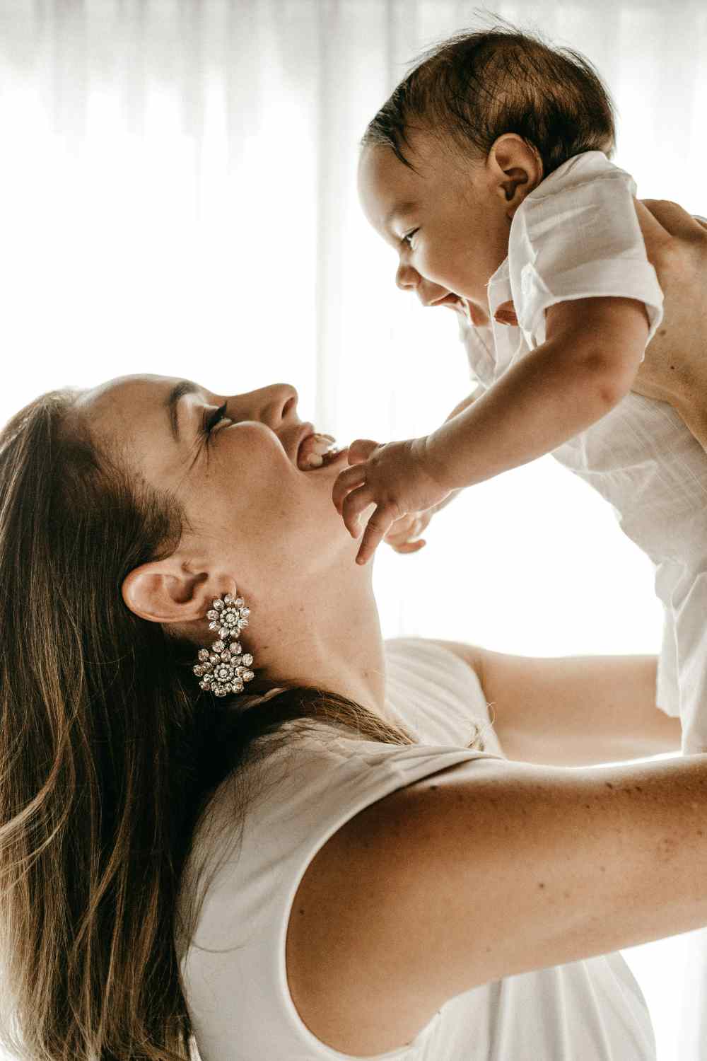 Mother lifting her smiling baby into the air
