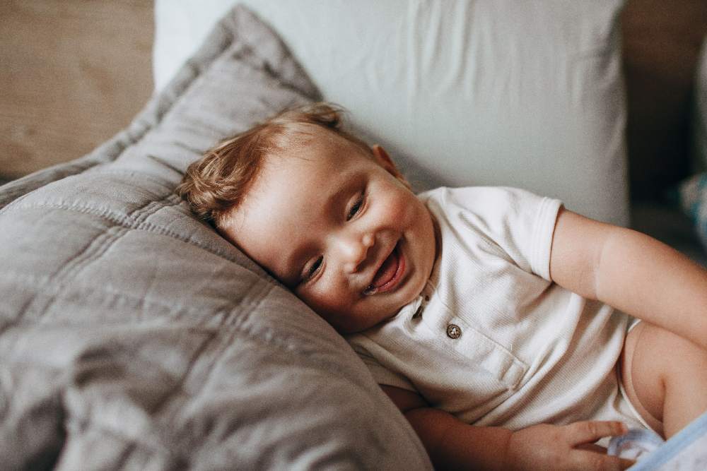 Rare Christian boy names: smiling baby boy resting on a pillow