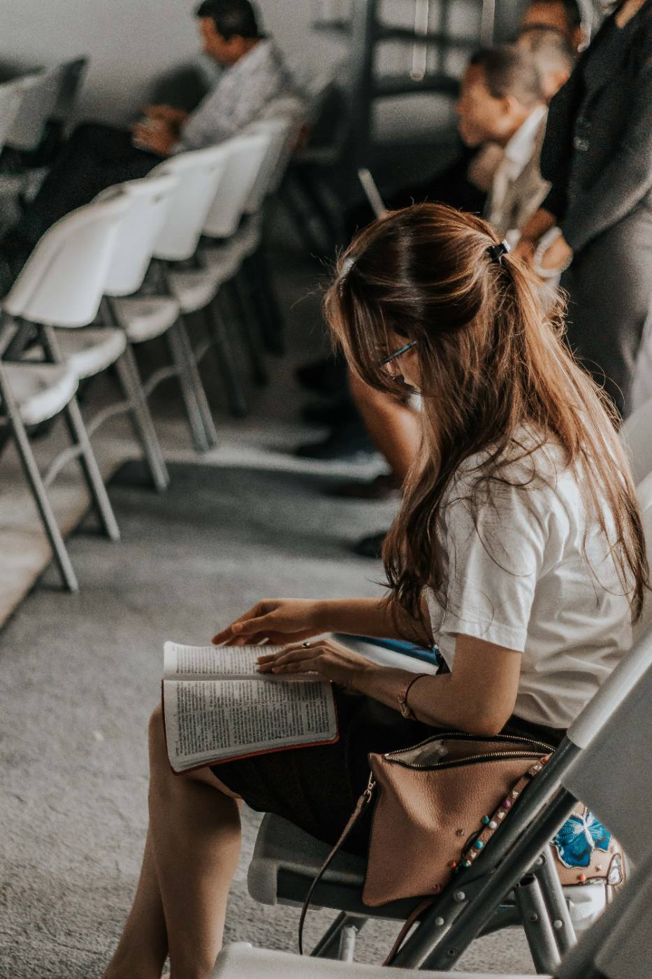 Young woman reading her Bible quietly during a church gathering